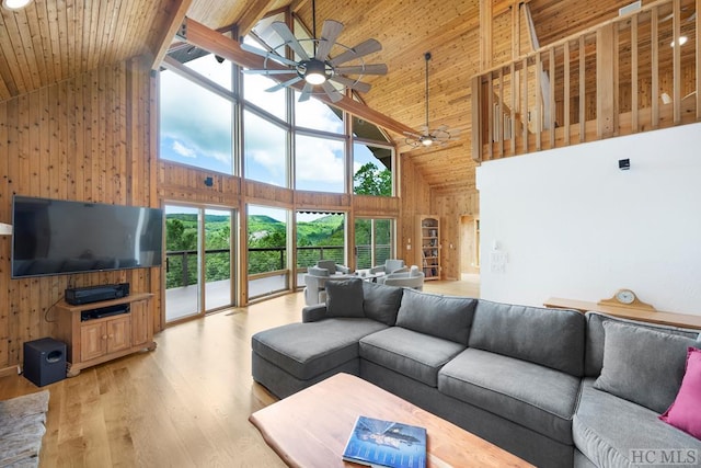 living room with hardwood / wood-style flooring, ceiling fan, high vaulted ceiling, wooden ceiling, and beamed ceiling