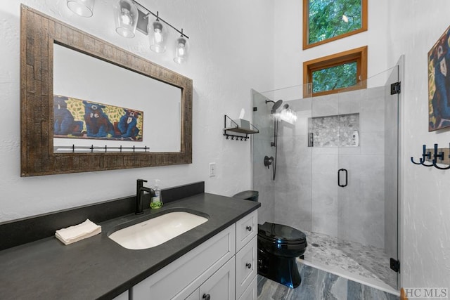 bathroom with vanity, toilet, a shower with shower door, and hardwood / wood-style floors