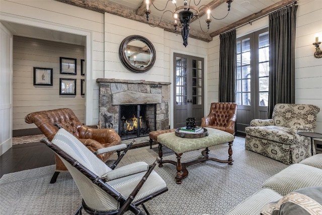 living room with wood walls, a fireplace, wood finished floors, and a notable chandelier