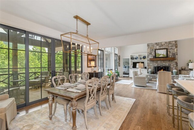 510 Boiling Springs Rd, Sapphire, NC 28774 - dining area featuring wood finished floors, a fireplace, and a chandelier