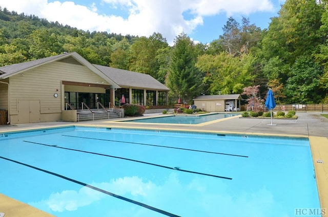 view of pool with a patio area and an outdoor structure