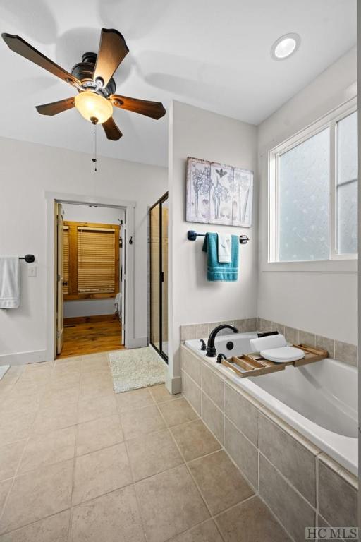 bathroom featuring ceiling fan, tile patterned flooring, and independent shower and bath