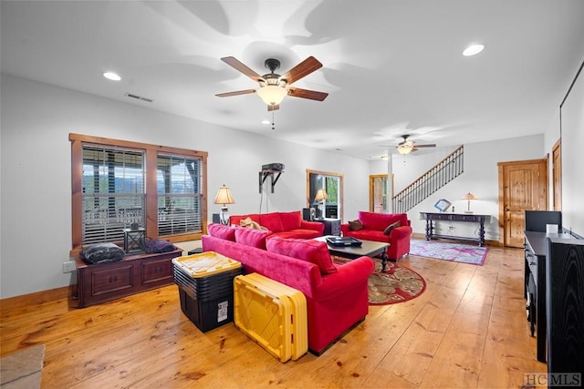 living room with light wood-type flooring, ceiling fan, and a wealth of natural light