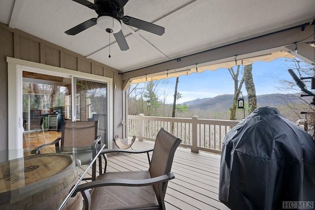 sunroom featuring a mountain view and ceiling fan