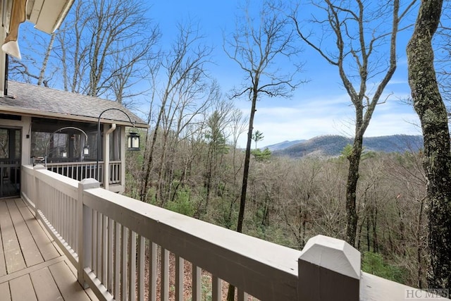 deck with a sunroom and a mountain view