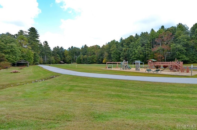 view of home's community featuring a playground and a yard