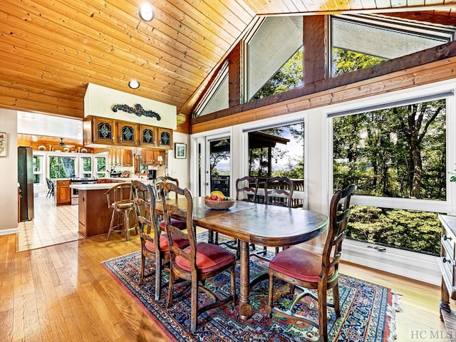 dining area featuring wood ceiling, plenty of natural light, high vaulted ceiling, and light wood-type flooring