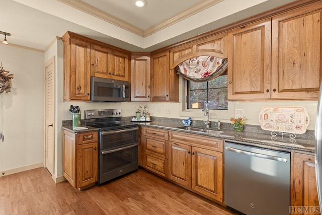 kitchen featuring crown molding, stainless steel appliances, light hardwood / wood-style floors, and sink