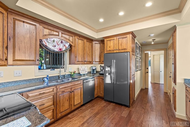 kitchen with sink, dark stone countertops, stainless steel appliances, ornamental molding, and dark hardwood / wood-style flooring