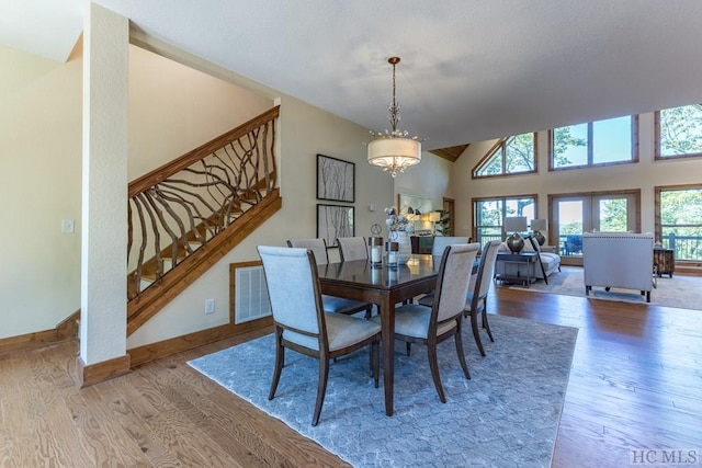 dining space featuring an inviting chandelier, hardwood / wood-style flooring, and vaulted ceiling