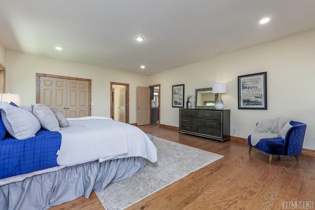 bedroom with dark wood-type flooring and a closet