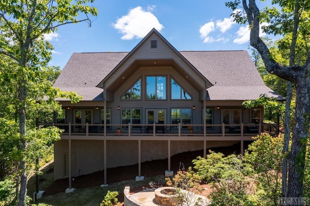 back of property featuring french doors, a deck, and a fire pit