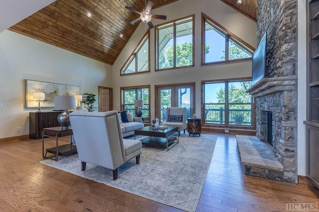 living room with high vaulted ceiling, a fireplace, built in features, and hardwood / wood-style floors