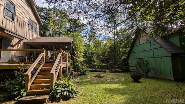 view of yard featuring a wooden deck and a fire pit