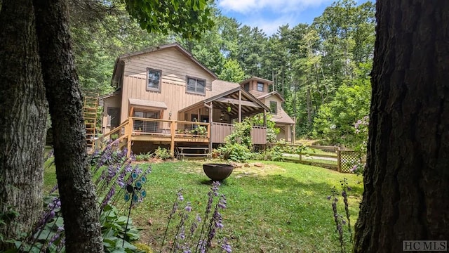 back of house with a wooden deck and a yard