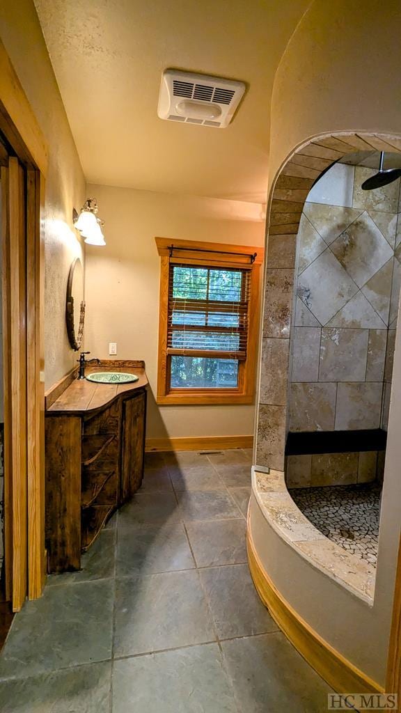 bathroom featuring a shower and vanity