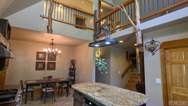 interior space with a high ceiling, light stone countertops, stove, and a chandelier