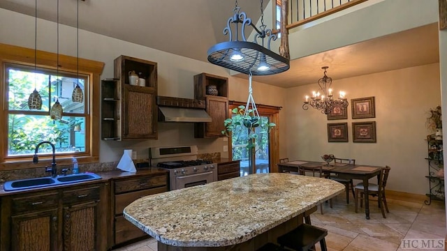 kitchen featuring a kitchen island, sink, high end stainless steel range, and plenty of natural light