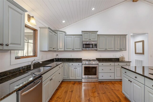 1034 E Rochester Dr, Cashiers, NC 28717 - kitchen featuring stainless steel appliances, a sink, gray cabinetry, light wood finished floors, and dark stone counters
