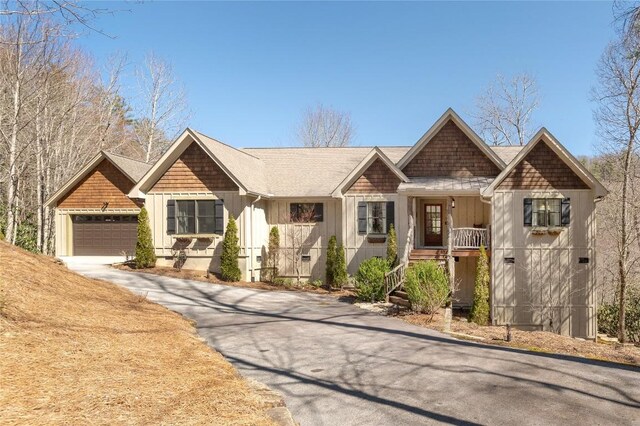 1034 E Rochester Dr, Cashiers, NC 28717 - view of front of house featuring board and batten siding, a porch, a garage, driveway, and stairs