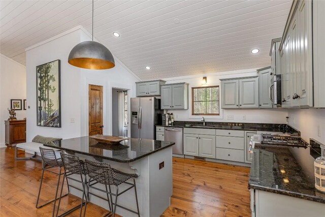 1034 E Rochester Dr, Cashiers, NC 28717 - kitchen with stainless steel appliances, a sink, gray cabinetry, vaulted ceiling, and a kitchen breakfast bar