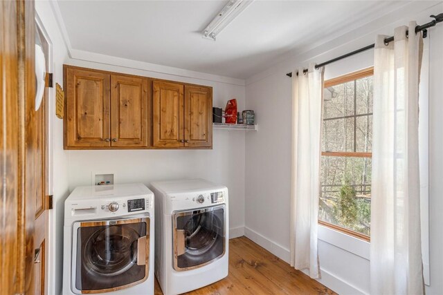 1034 E Rochester Dr, Cashiers, NC 28717 - washroom featuring washing machine and clothes dryer, healthy amount of natural light, light wood-style floors, and cabinet space