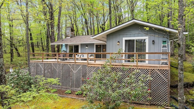 back of property with a deck and a chimney