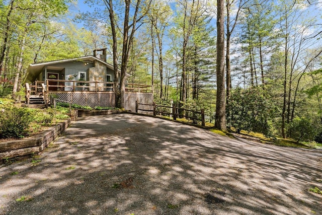 view of property exterior with a chimney and a deck