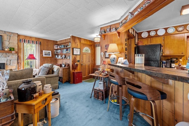 carpeted living room with wood walls and ornamental molding
