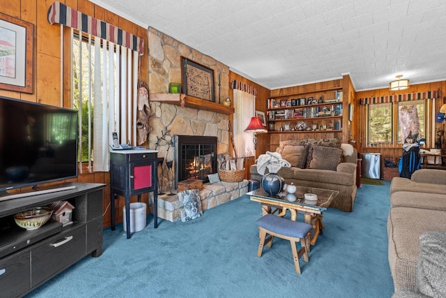 carpeted living room featuring wooden walls and a fireplace