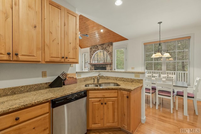 kitchen with sink, light stone counters, light wood-type flooring, stainless steel dishwasher, and pendant lighting