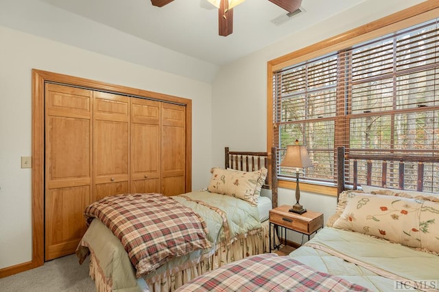 carpeted bedroom featuring ceiling fan, lofted ceiling, and a closet