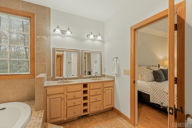 bathroom with vanity, tile patterned floors, and tiled bath