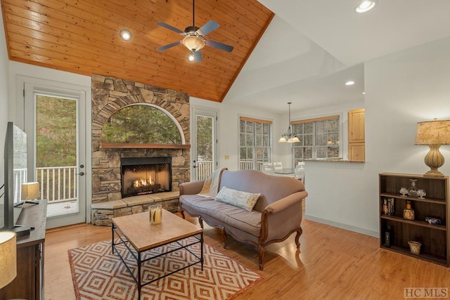 living room with lofted ceiling, plenty of natural light, a fireplace, light hardwood / wood-style floors, and wooden ceiling