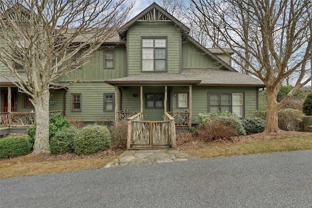 view of front of house with board and batten siding, a shingled roof, and a porch