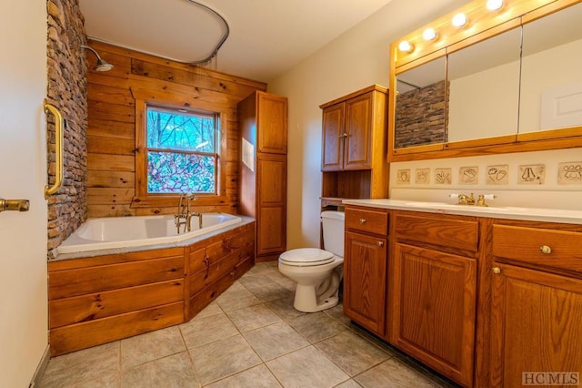 bathroom featuring wooden walls, vanity, tile patterned floors, toilet, and a bathing tub