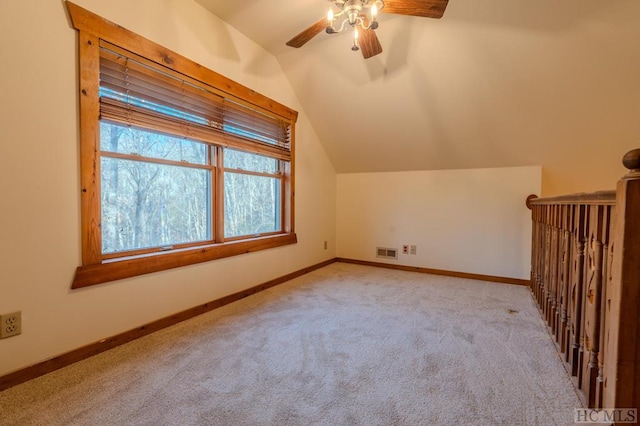 additional living space with ceiling fan, lofted ceiling, and light colored carpet