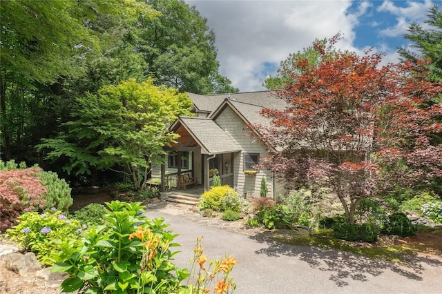 614 Fairway Dr, Lake Toxaway, NC 28747 - view of property hidden behind natural elements with a porch and a shingled roof