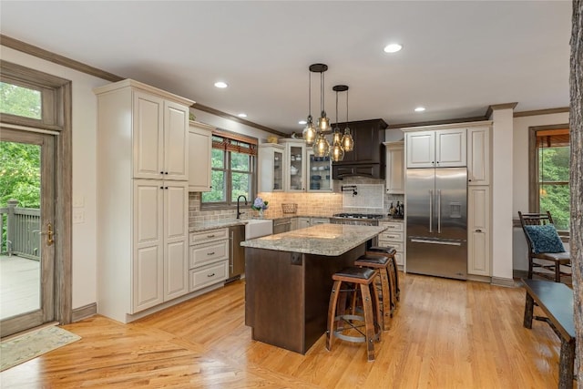 614 Fairway Dr, Lake Toxaway, NC 28747 - kitchen featuring built in fridge, ornamental molding, backsplash, a kitchen breakfast bar, and light stone counters