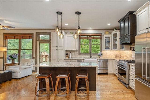 614 Fairway Dr, Lake Toxaway, NC 28747 - kitchen with premium appliances, a breakfast bar, plenty of natural light, decorative backsplash, and crown molding
