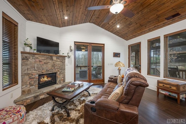 living room featuring ceiling fan, a stone fireplace, dark hardwood / wood-style floors, and wood ceiling