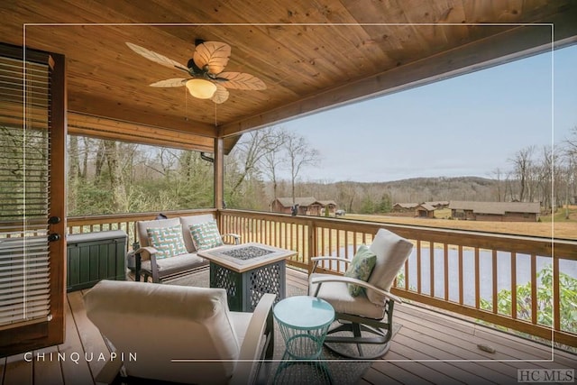 deck with an outdoor living space with a fire pit and ceiling fan