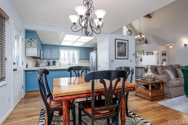 dining room with light wood-type flooring and a chandelier