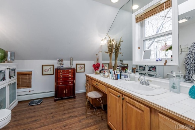 bathroom with toilet, vaulted ceiling, baseboard heating, vanity, and hardwood / wood-style floors