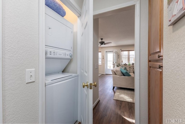 clothes washing area featuring ceiling fan, stacked washer and clothes dryer, and dark hardwood / wood-style floors