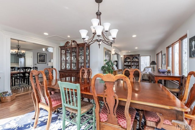 dining space with hardwood / wood-style flooring and a notable chandelier