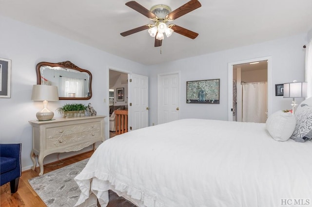 bedroom featuring ceiling fan, ensuite bathroom, and hardwood / wood-style floors