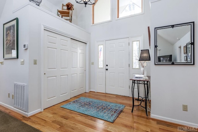 entryway featuring hardwood / wood-style floors, a towering ceiling, and a wealth of natural light