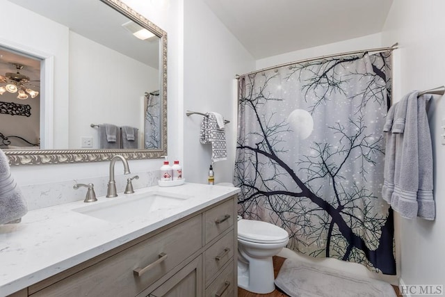 bathroom featuring vanity, curtained shower, and toilet