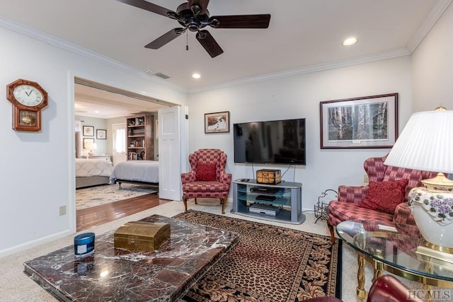 carpeted living room with crown molding and ceiling fan